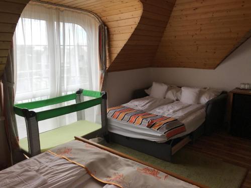 1 dormitorio con 2 camas y ventana en Zöldtető Panzió en Balatonfüred