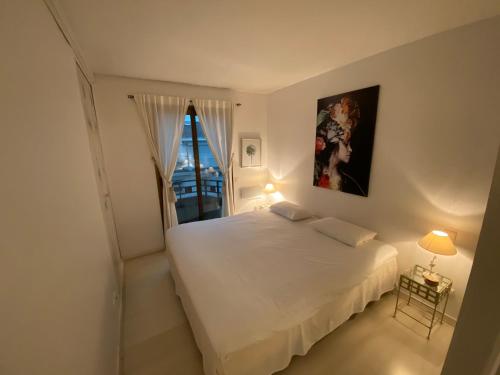 a bedroom with a white bed and a window at Riviera Eden Palace in Cannes