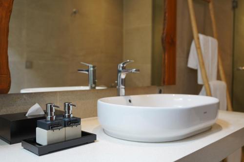a bathroom with a white sink and a mirror at Umah Tirta in Ubud