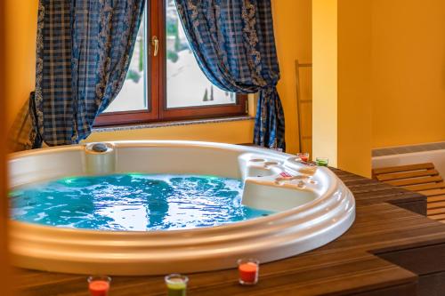 a large bath tub with blue water in a room at Stupnički Dvori Winery Hotel in Brodski Stupnik