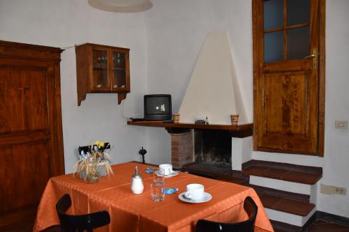 a dining room with a table and a fireplace at Borgo Vecchio in Montalcino