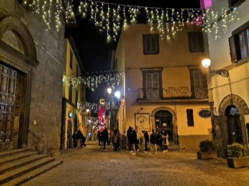 ヴィトルキアーノにあるLocazione Turistica Vicolo delle Cordonateのクリスマスの灯りを持って歩く人々