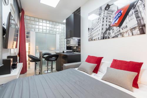 a bedroom with a large white bed with red pillows at Gran Vía Apartment in Madrid