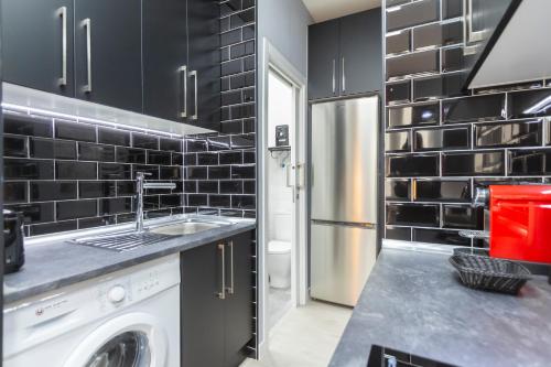 a kitchen with a sink and a washing machine at Gran Vía Apartment in Madrid