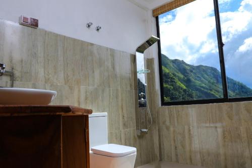 a bathroom with a shower and a toilet and a window at Ella Camelot in Ella