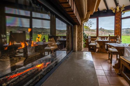 a fireplace in a restaurant with tables and chairs at Stupnički Dvori Winery Hotel in Brodski Stupnik