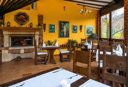 a dining room with yellow walls and a fireplace at Stupnički Dvori Winery Hotel in Brodski Stupnik