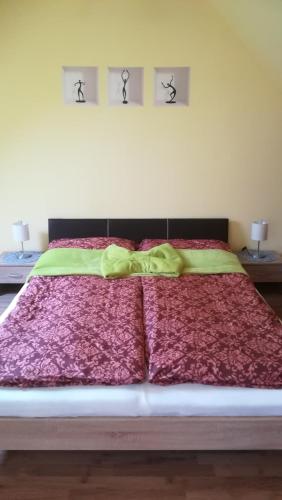 a bedroom with a large bed with red comforter at MA-JA apartman in Bük