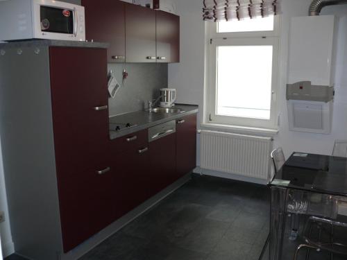 a kitchen with brown cabinets and a window at Ferienwohnung Speyer in Speyer