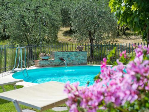 una piscina con una fuente en un patio en Apartment Lari-1 by Interhome, en Luiano