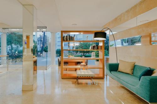 パルマ・デ・マヨルカにあるHesperia Ciudad de Mallorcaのリビングルーム(緑のソファ、椅子付)