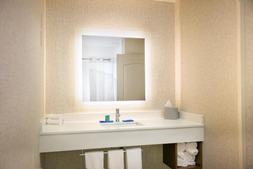 ein Bad mit einem Waschbecken und einem Spiegel in der Unterkunft Holiday Inn Express & Suites Wausau, an IHG Hotel in Weston