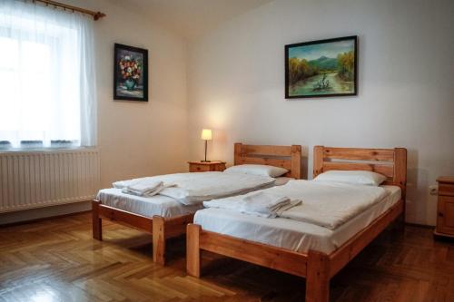two twin beds in a room with a window at Erzsébet Pince in Tokaj