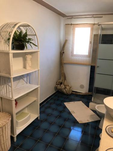a bathroom with a blue tiled floor and a shelf at Mas du tilleul in Callian