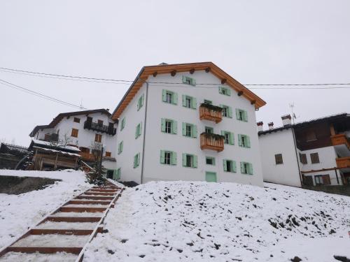 a large white building with snow on the ground at La Rocia 2 in Rocca Pietore