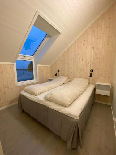 1 dormitorio con 1 cama en una habitación con ventana en Rorbu by Nappstraumen, Lofoten en Gravdal