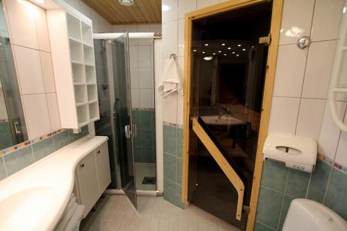 a bathroom with a shower and a sink and a toilet at Spa Hotel Rauhalahti in Kuopio