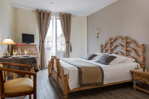 1 dormitorio con cama, mesa y ventana en Hôtel Restaurant Le Bristol, en Niederbronn-les-Bains