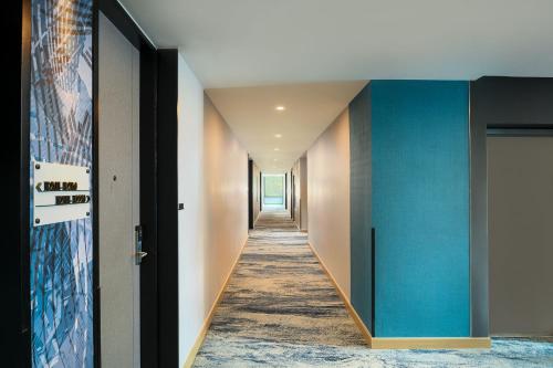a hallway with blue walls and a blue door at Holiday Inn & Suites Siracha Laemchabang by IHG in Si Racha
