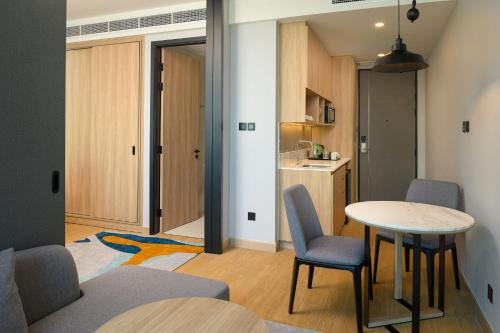 a room with a table and chairs and a kitchen at Holiday Inn & Suites Siracha Laemchabang by IHG in Si Racha