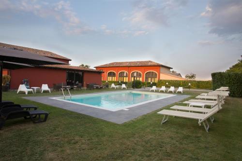 a swimming pool with lounge chairs and a house at Corte Di Frara in Parma