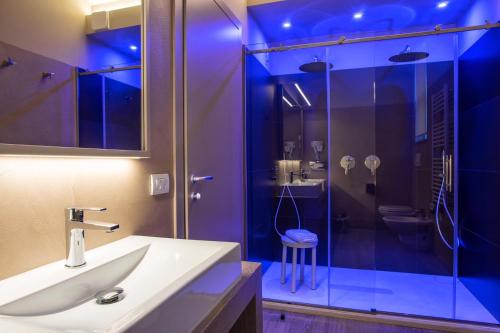a bathroom with a sink and a glass shower at Guesia Village Hotel e Spa in Foligno