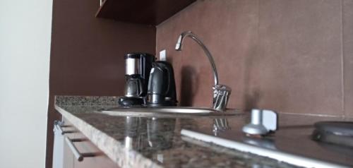 um balcão de cozinha com um lavatório e comodidades para preparar café em Madera Suite · Rosario centro y costanera em Rosário