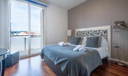 sypialnia z dużym łóżkiem i dużym oknem w obiekcie You Stylish City Center Apartments w Barcelonie