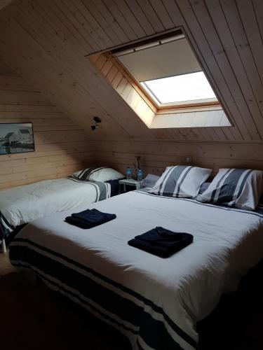 - une chambre avec un grand lit blanc et une lucarne dans l'établissement LES CHEVAUX DE L'HIPPOCAMPE, à Mont-Dol