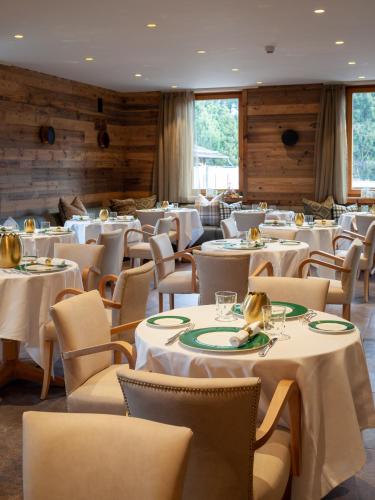 a dining room with white tables and chairs at Asiago Sporting Hotel & Spa in Asiago