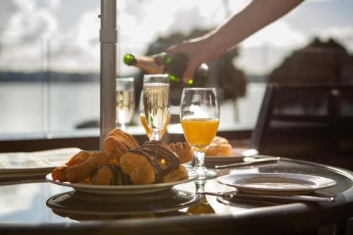 a table with a plate of bread and two glasses of wine at Pioneer Waterfront Apartments in Paihia