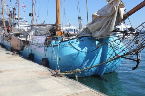 un barco azul atado a un muelle en el agua en Korriganez - Festival Interceltique, en Lorient