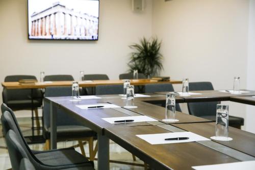 a conference room with tables and chairs and a screen at Athens Starlight Hotel in Athens