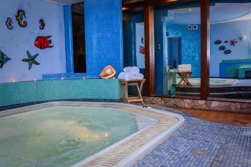 a jacuzzi tub in a room with a swimming pool at Willa Bryza in Gdynia