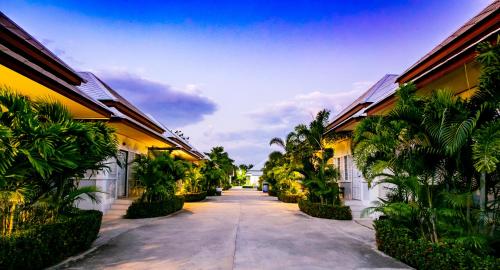a street between two buildings with palm trees at Bualuang Boutique Resort in Ang Thong