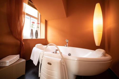 a bathroom with a tub and a window at Seminar & Urlaubshotel Oststeirischer Hof Söchau in Söchau