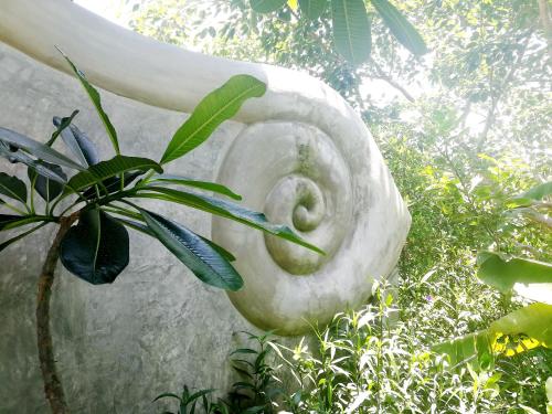a white statue of a plant next to a plant at Ping Pool Villa 2 in Mae Rim