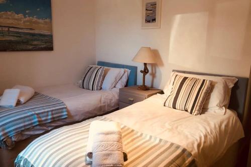 a bedroom with two beds with towels on them at Bay House Lobber Port Isaac Apartment with Sea Views in Port Isaac