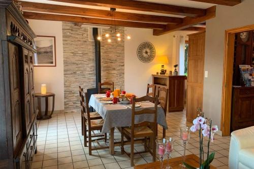 une cuisine et une salle à manger avec une table et des chaises dans l'établissement Gîte du Cosquer, à Landudec