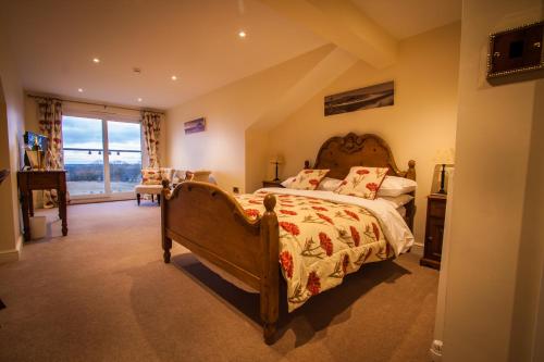 a bedroom with a large bed and a large window at Dene House Farm in Longframlington