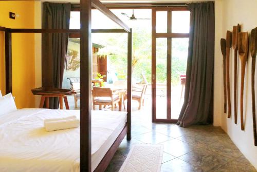 a bedroom with a bed and a patio with a table at Ping Pool Villa 2 in Mae Rim
