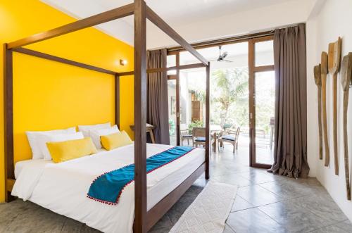 um quarto com uma cama e uma parede amarela em Ping Pool Villa 2 em Mae Rim