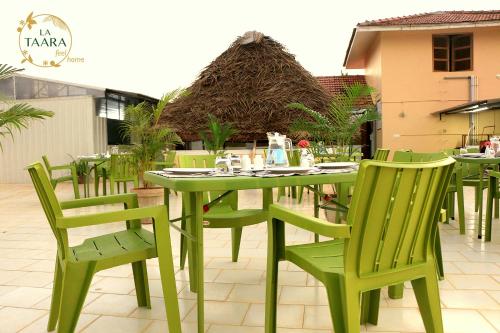 a green table and chairs on a patio at La Taara - Feel Home in Auroville