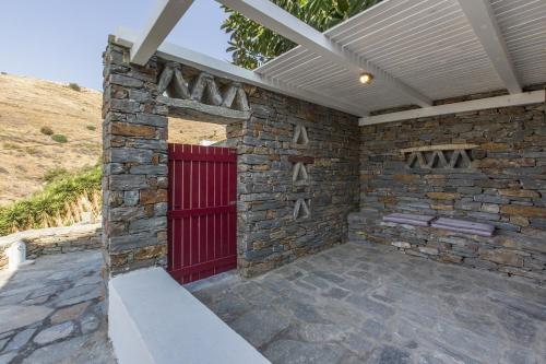 a brick wall with a red door on a patio at Apartment with a sea view and swimming pool, in the area of Koundouros in Koundouros