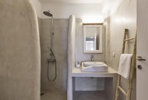 y baño con lavabo y ducha. en Apartment with a sea view and swimming pool, in the area of Koundouros, en Koundouros