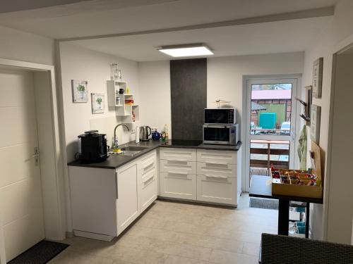 a kitchen with white cabinets and a counter top at Das kleine Schwarze in Parsau
