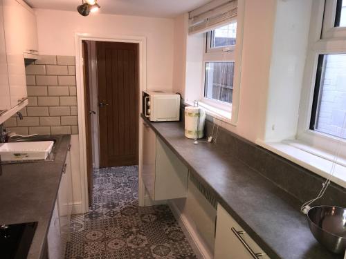 a kitchen with a counter top with a microwave at Ground Floor Contemporary 1 Bed Apartment in Birmingham