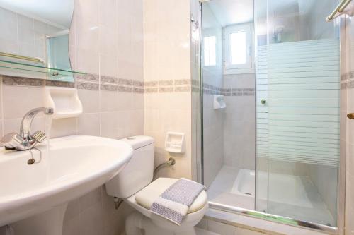 a bathroom with a toilet and a sink and a shower at Kerasoula Apartments in Yénion