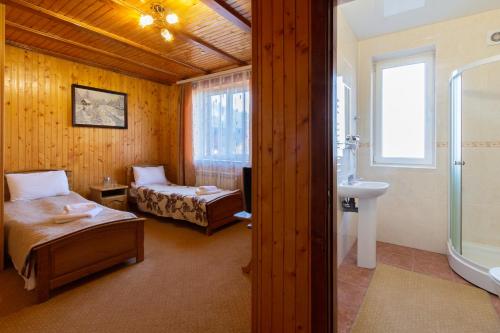 a room with two beds and a bathroom with a sink at У Мар'яни і Назара in Yaremche