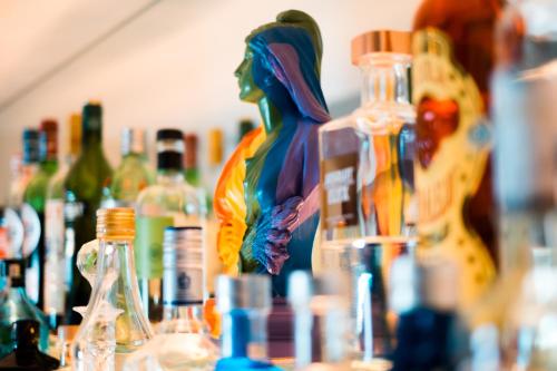 a statue of a woman is sitting on a table with bottles at The Late Birds Lisbon - Gay Urban Resort in Lisbon